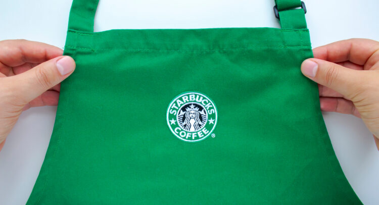 An Starbucks employee holding a store branded apron.